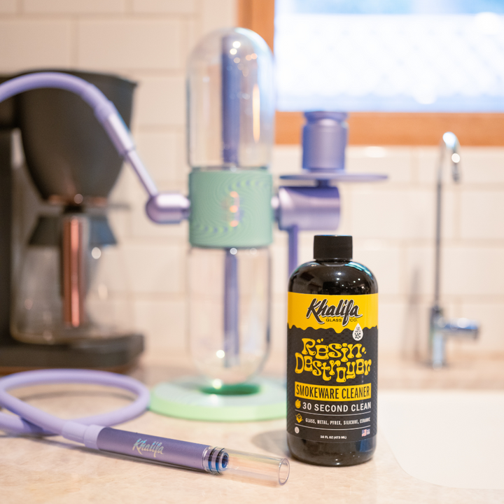 Khalifa Smokeware Cleaner bottle on a kitchen counter with smoking accessories.